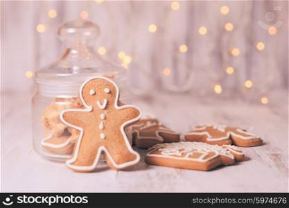 Gingerbread cookies on a table and Christmas lights on background. Gingerbread cookies