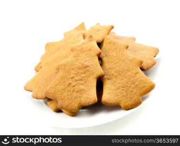 Gingerbread cookies, tree shape, on white plate towards white background