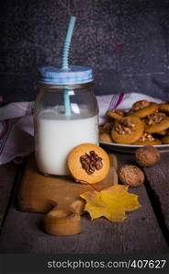 gingerbread cookies with walnuts on a table and a cup of milk