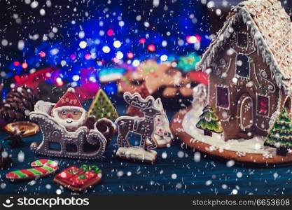 Gingerbread house and figures with lights on dark background, xmas theme. Gingerbread house with lights
