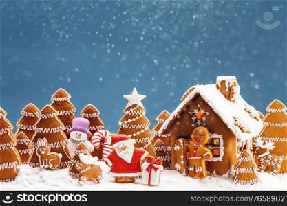 Gingerbread house christmas fir trees Santa Claus and gift cookies winter holiday celebration concept. Gingerbread house and trees