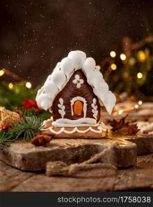 Gingerbread house on a rustic table with Christmas decoration