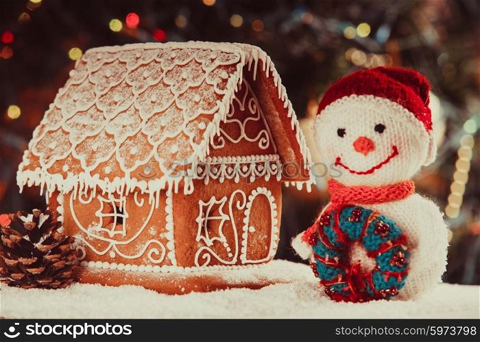 gingerbread house on the snow, snowman and candlestick