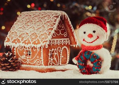 gingerbread house on the snow, snowman and candlestick