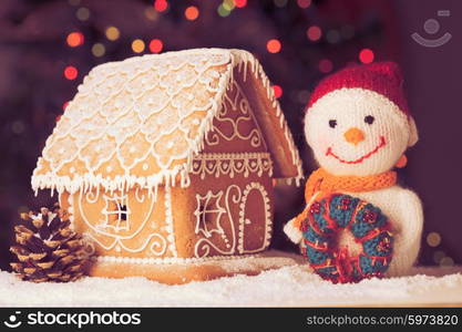 gingerbread house on the snow, snowman and candlestick