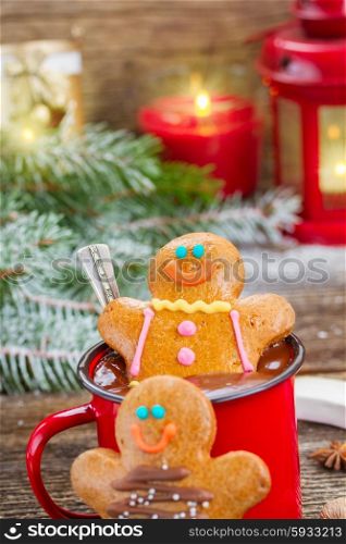 Gingerbread men with mug of hot chocolate. two Gingerbread men with mug of chocolate and glowing lanterns and christmas tree