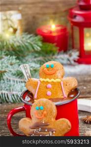 Gingerbread men with mug of hot chocolate. two Gingerbread men with mug of chocolate and glowing lanterns and christmas tree