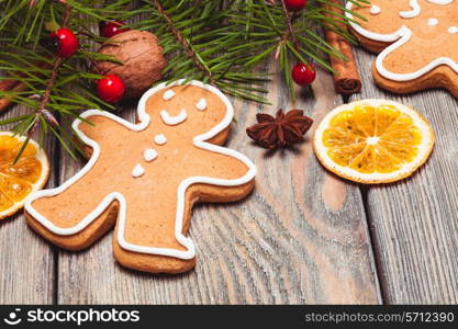 Gingerbreads and fir tree branches on the wooden table. Christmas decor