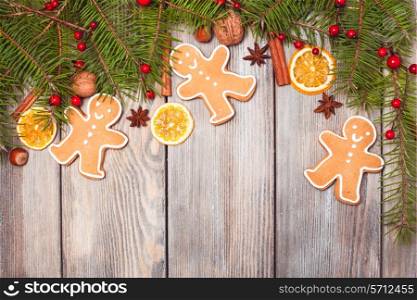 Gingerbreads and fir tree branches on the wooden table. Christmas decor
