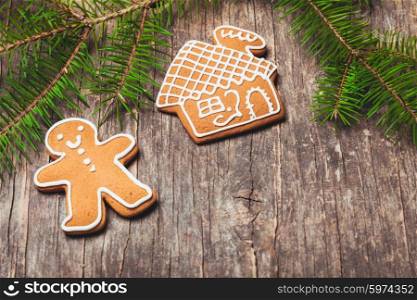 Gingerbreads and fir tree branches on the wooden table. Christmas decor. Gingerbreads and fir tree