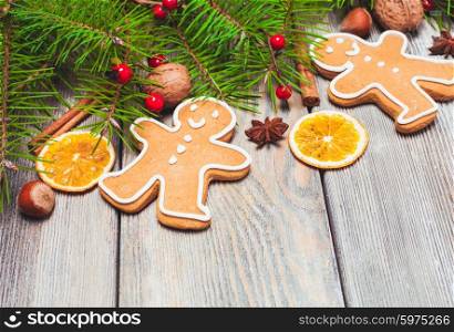 Gingerbreads and fir tree branches on the wooden table. Christmas decor. Gingerbreads and fir tree