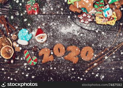 Gingerbreads cookies for 2020 new year on wooden background, xmas theme. Gingerbreads for new years and christmas