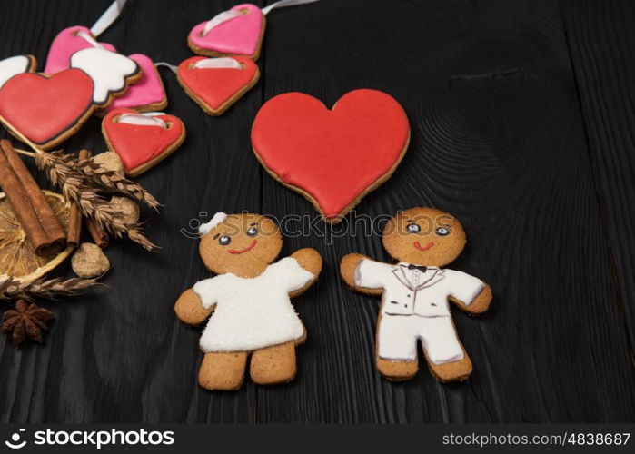 Gingerbreads for Valentines Day. Gingerbreads for Valentines Day or wedding theme on black wooden background