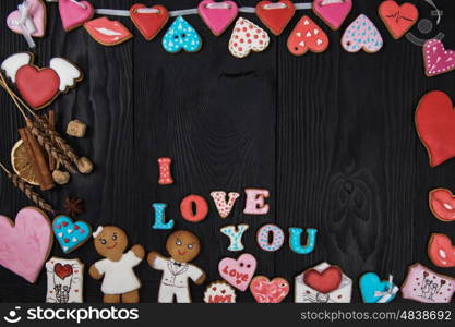 Gingerbreads for Valentines Day. Gingerbreads for Valentines Day or wedding theme on black wooden background