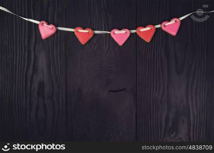 Gingerbreads for Valentines Day. Gingerbreads for Valentines Day or wedding theme on black wooden background