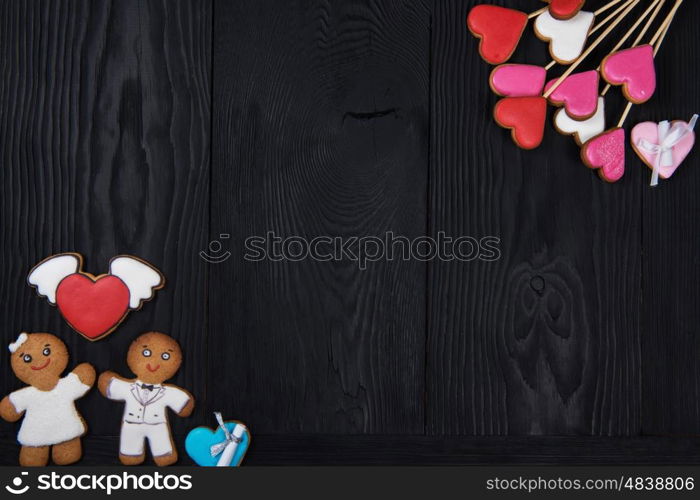 Gingerbreads for Valentines Day. Gingerbreads for Valentines Day or wedding theme on black wooden background