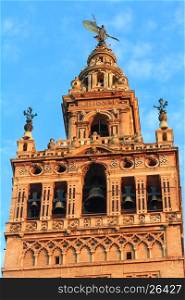 Giralda bell tower top on blue sky background. Seville, Spain. Constructed in 1184-1198.