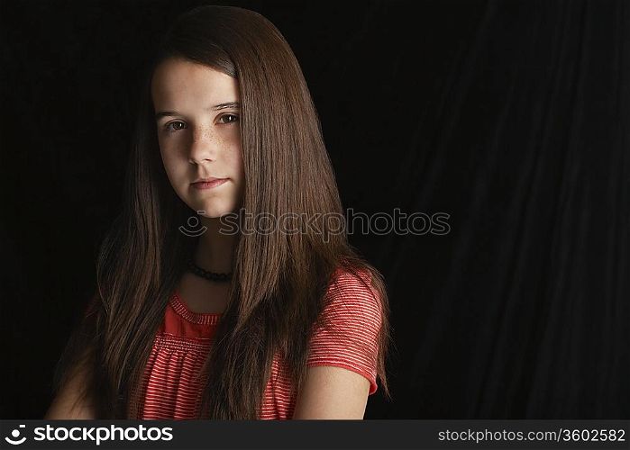 Girl (13-15) on black background portrait