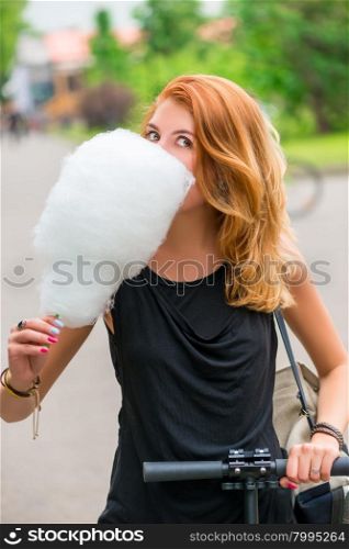 Girl 30 years walking in the park and eat cotton candy