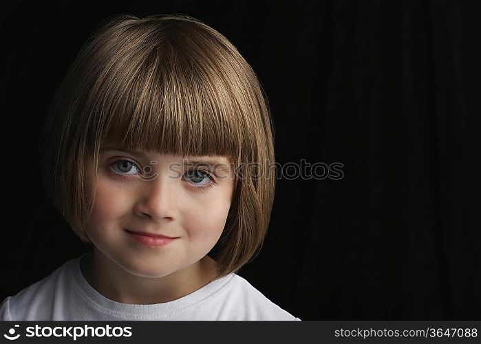 Girl (5-6) on black background portrait close-up