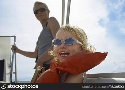 Girl (5-6) with mother on yacht, focus on foreground