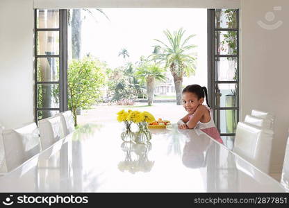 Girl (5-6 years) sitting at dining table