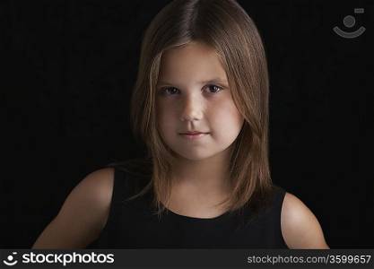 Girl (7-9) on black background portrait