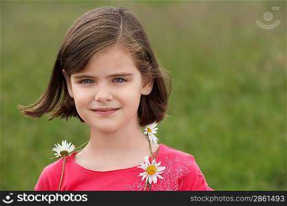 Girl (7-9) wearing ring of flowers in meadow, portrait