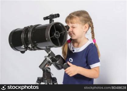 Girl amateur astronomer sets up a telescope for observing the starry sky