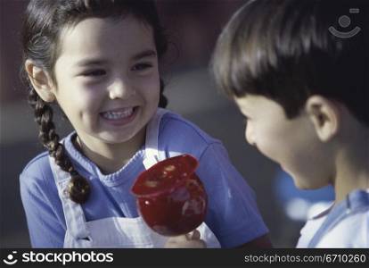 Girl and a boy sitting together holding a candy apple