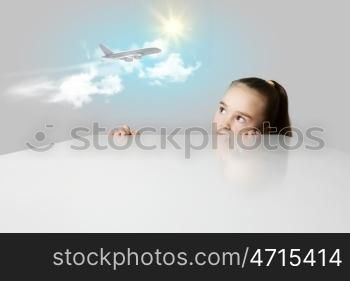 Girl and airplane in sky. Little adorable girl looking at flying airplane