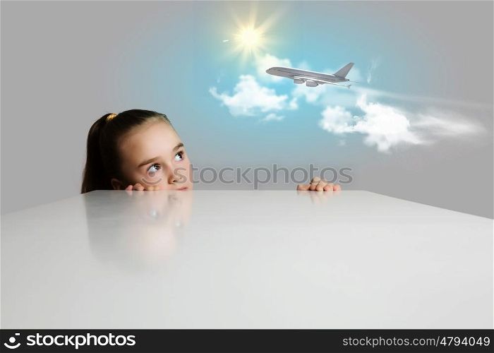 Girl and airplane in sky. Little adorable girl looking at flying airplane