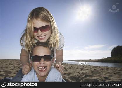 Girl and boy with sunglasses at beach