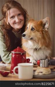 girl and corgi dog posing in the kitchen

