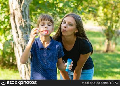 Girl and girl blow bubbles together