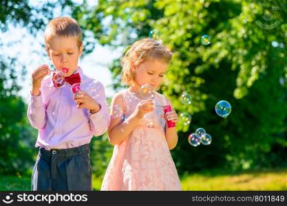girl and her friend with soap bubbles in the park