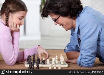Girl and her grandmother playing chess