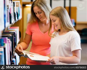 Girl and her mother in library choosing books. Girl and her mother in library