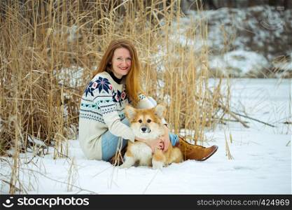 girl and little cute corgi fluffy puppy at the outdoor. Winter