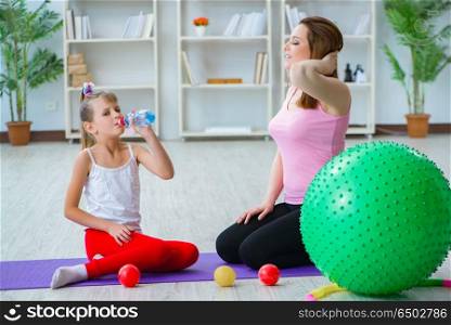Girl and mother exercising at home