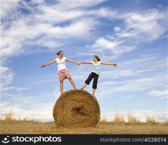 girl and woman standing on hay bale