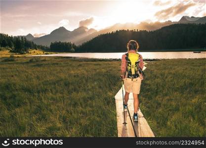 Girl approaches an alpine lake during a solo excursion in the mountains