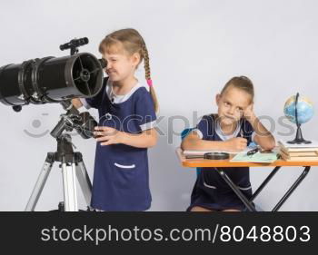 Girl astronomer looks through the eyepiece of the telescope, the other girl thinking waiting for the results of observations