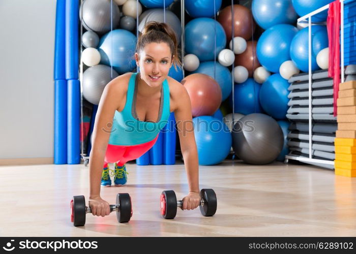 Girl at gym push-up strength pushup exercise with dumbbells workout