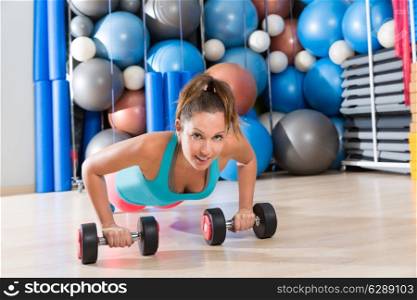 Girl at gym push-up strength pushup exercise with dumbbells workout