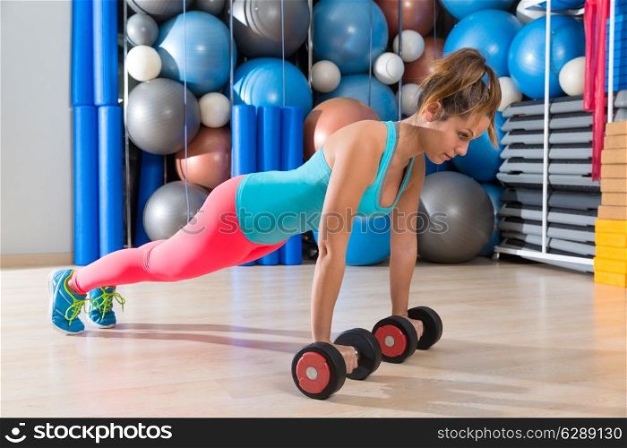 Girl at gym push-up strength pushup exercise with dumbbells workout