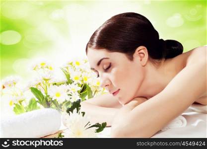 Girl at spa massage. Young pretty woman with clear skin at spa salon getting massage