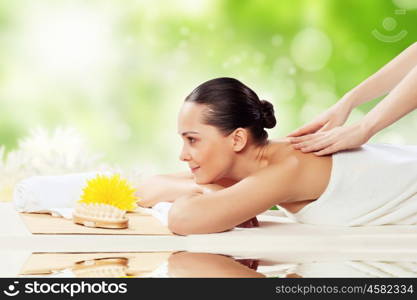 Girl at spa massage. Young pretty woman with clear skin at spa salon getting massage