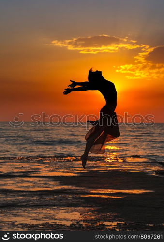 girl at sunset. Girl jumping on a background of sea sunset