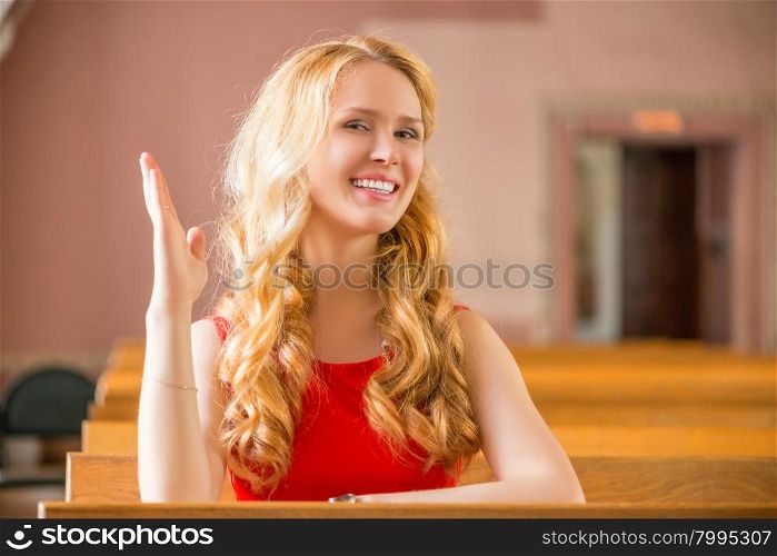 girl at the desk with a raised hand is ready to answer a lesson